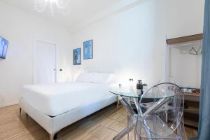 a white bedroom with a bed and a glass table at Città Studi Suites - Top Collection in Milan