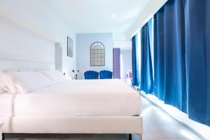 a bedroom with a white bed and blue curtains at Città Studi Suites - Top Collection in Milan