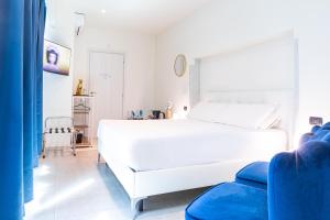a white bedroom with a white bed and a blue couch at Città Studi Suites - Top Collection in Milan