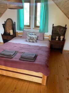 una camera da letto con un grande letto con tende blu di Domek z sauną i balią w Borach tucholskich a Bysław