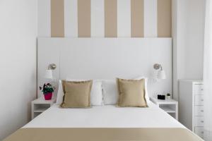 a white bedroom with a large white bed with pillows at Hotel Aqua in Cattolica +29 photos