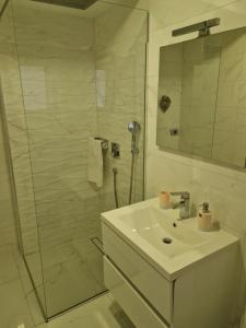 ein weißes Badezimmer mit Waschbecken und Dusche in der Unterkunft Novi Lux in Novi Vinodolski + 13 Fotos