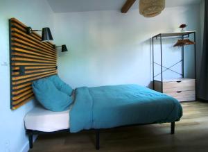 a bedroom with a bed with a blue blanket at Caoubère in Bagnères-de-Bigorre