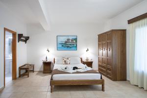 a bedroom with a bed and a wooden cabinet at Nina's House in Achladies