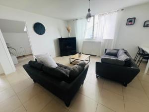 a living room with two couches and a table at Agréable appartement proche de disney in Chanteloup-en-Brie