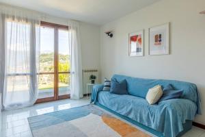 a blue couch in a living room with a window at "Panorama sul Lago" Lake Maggiore, Free Wifi Netflix and Tennis in Brezzo