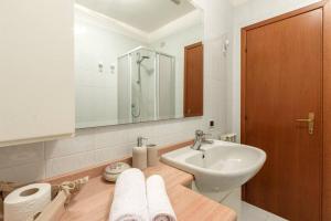 a white bathroom with a sink and a mirror at "Panorama sul Lago" Lake Maggiore, Free Wifi Netflix and Tennis in Brezzo