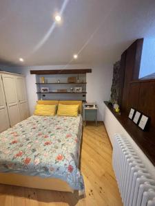 a bedroom with a bed with a floral bedspread at La Bombetta Gialla di Elisa e Marco in Morgex