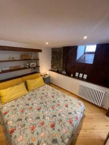 a bedroom with a bed with a floral bedspread at La Bombetta Gialla di Elisa e Marco in Morgex