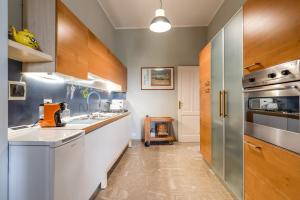 サンタ・チェザーレア・テルメにあるVilla Vallettaのキッチン(白いカウンター、木製キャビネット付)