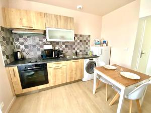 a kitchen with a table and a sink and a microwave at L'Aristide, au calme avec parking in Limoges