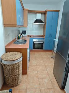 Una cocina con gabinetes azules y un fregadero. en Mirador de Las Salinas, en Los Cancajos