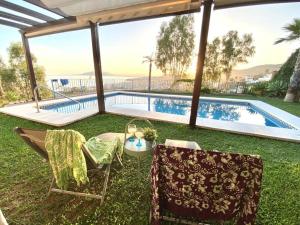 Un patio con dos sillas y una piscina. en Sea & Wave Buena Vista Pool Apartment, en Torre de Benagalbón 15 fotos más