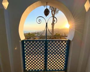 Una ventana arqueada con vista al atardecer. en Sea & Wave Buena Vista Pool Apartment, en Torre de Benagalbón