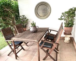 Una mesa y sillas de madera en un patio. en Sea & Wave Buena Vista Pool Apartment, en Torre de Benagalbón