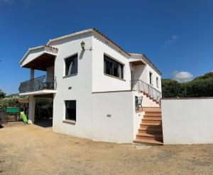 une maison blanche avec un escalier sur son côté dans l'établissement Mas Tauler, à Sant Antoni de Calonge