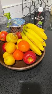 a plate of fruit with apples oranges and bananas at Private room in homestay in Ashhurst