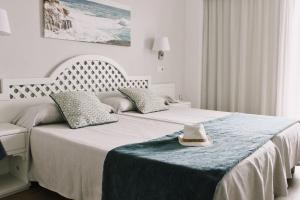 Кровать или кровати в номере Hotel Pinos Playa