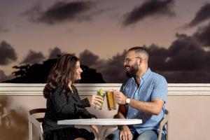 a man and a woman sitting at a table with a drink at Hodelpa Caribe Colonial in Santo Domingo