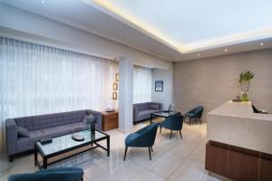 a living room with a couch and tables and chairs at Hodelpa Caribe Colonial in Santo Domingo +70 photos