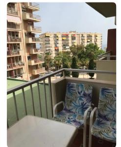 Un balcón con dos sillas y una mesa en un balcón. en Apartamento Júpiter - Minerva, en Benalmádena