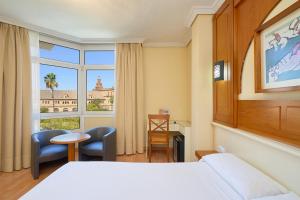 a hotel room with a bed and a window at Hotel Pasarela in Seville