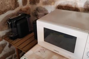 a microwave oven sitting on top of a table at Casa da Padeira in Trancoso