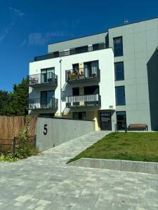 un edificio blanco con un balcón con gente. en Donna Aparts 2, en Jastrzębia Góra