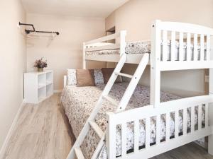 Una litera blanca en una habitación pequeña con una litera. en Apartamento vacacional Zamudio, en Zamudio