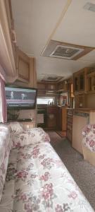 a room with a bed and a kitchen with a tv at Kemping Pod Babią Górą in Zawoja
