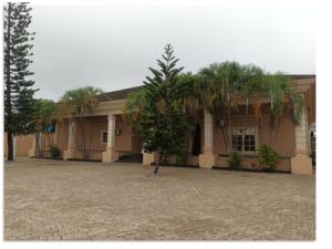 贝宁城Hotel Adonai Ltd的一座前面有棕榈树的建筑 更多10张照片
