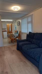 a living room with a blue couch and a table at Tullynawood Glamping and Farm in Darkley