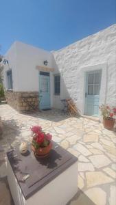 a building with a table with flowers on it at Chrisi's and Jasmin's house in Patmos