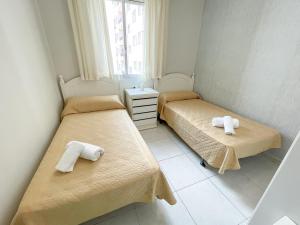 ポルトノボにあるApartamentos Portonovo 3000のベッドが2つと窓のある部屋