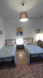 a bedroom with two beds and a lamp in it at Chrisi's and Jasmin's house in Patmos