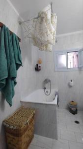 a bathroom with a bath tub and a window at Chrisi's and Jasmin's house in Patmos +39 photos