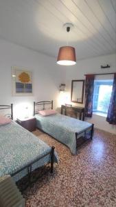 a bedroom with two beds and a window at Chrisi's and Jasmin's house in Patmos