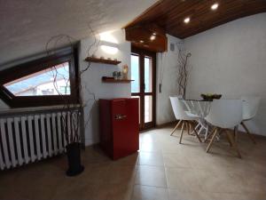 a room with a red refrigerator and a table and chairs at Vinadio Sole & Relax in Vinadio