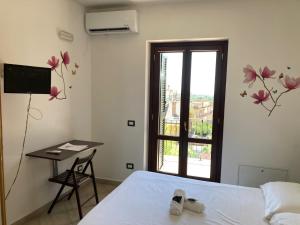 a bedroom with a bed and a desk and a window at SIMPLY INN close to TIVOLI in Marcellina