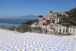 a balcony with a view of a town on a hill at The Dreamer's Terrace in Vico Equense