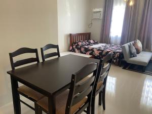 Un comedor con una mesa y sillas en una habitación. en spacious condo unit 1P olvera residences, en Bacolod 4 fotos más