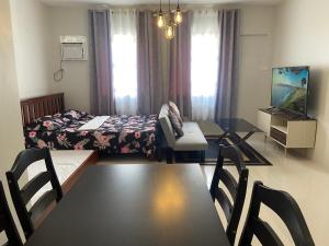 Un dormitorio con una cama y una mesa y sillas. en spacious condo unit 1P olvera residences, en Bacolod