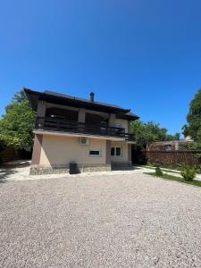 a house with a gravel driveway in front of it at Big City House in Bihać