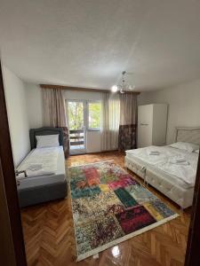 a bedroom with two beds and a rug on the floor at Big City House in Bihać +14 photos