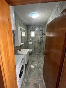 a bathroom with a sink and a washing machine at Big City House in Bihać +14 photos