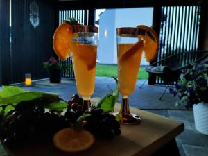 two glasses of orange juice and fruit on a table at DoriSol in Solec-Zdrój