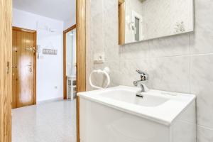 Un baño blanco con lavabo y espejo. en Sunflower Tailandia_Santa Pola, en Santa Pola