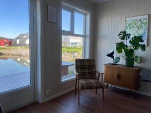 a living room with a chair and a window at Modern Fishermans Cabin in Ballstad