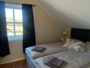 a bedroom with a bed with two towels on it at Modern Fishermans Cabin in Ballstad +7 photos