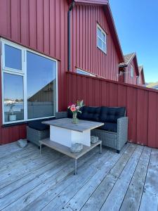 a patio with a couch and a table on a building at Modern Fishermans Cabin in Ballstad
